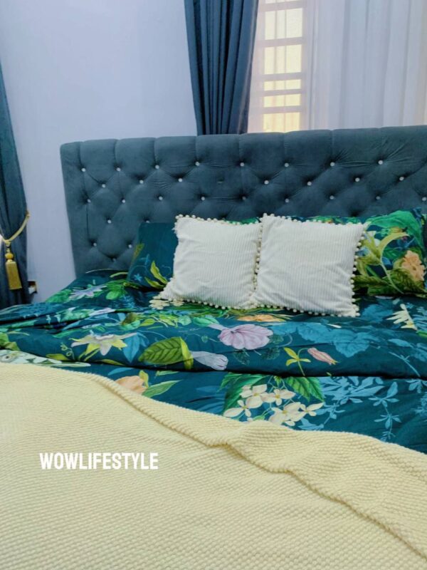 Green flowery polished cotton bedding set on a bed, includes bedsheet, duvet cover, and pillowcases.